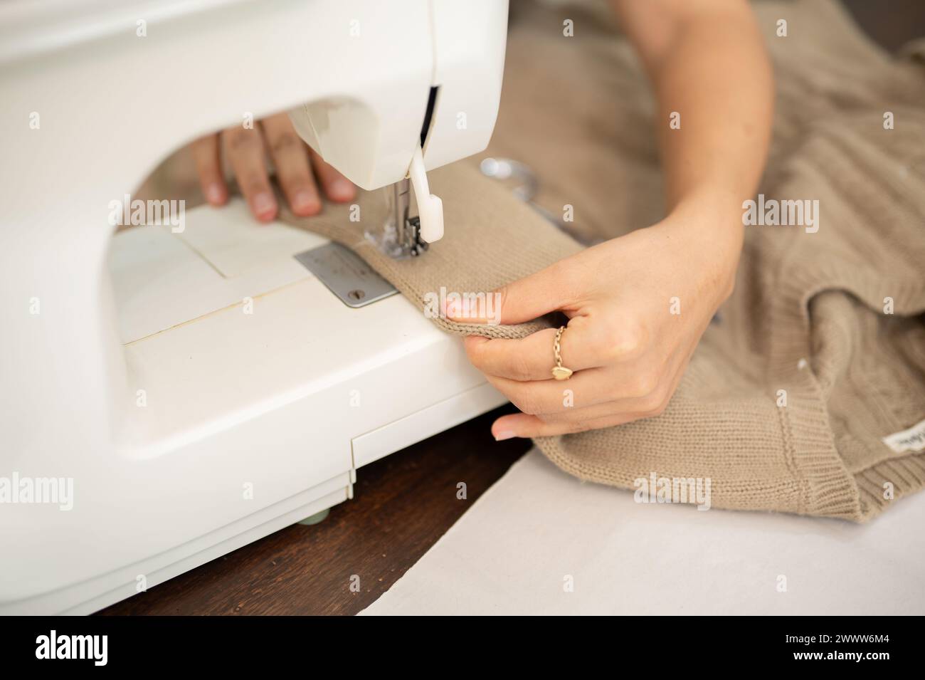 Una imagen de primer plano de una sastre femenina es coser un vestido con una máquina de coser, trabajando en su estudio. diseñador de moda, costurera, modisto Foto de stock