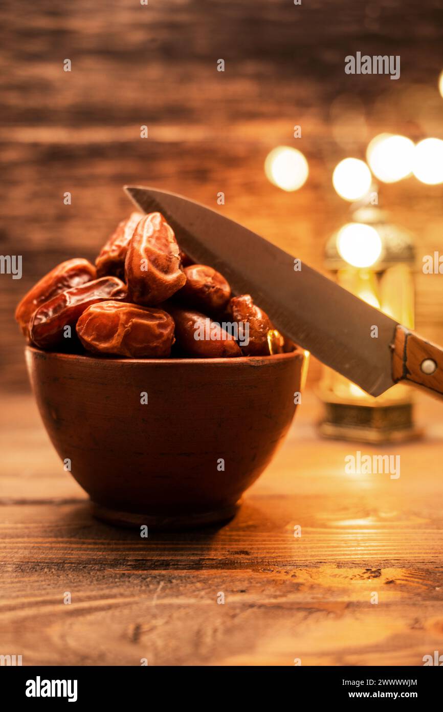 Imagen de sabrosos dátiles secos frutas y cuchillos con fondo ligero árabe. La fiesta musulmana del mes santo de Ramadán Kareem. Vegetariano y saludable Foto de stock