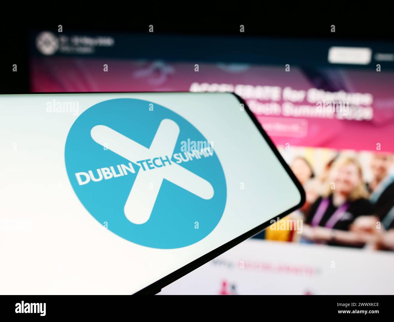 Teléfono móvil con el logotipo de la conferencia de tecnología Dublin Tech Summit (DTS) frente al sitio web de negocios. Enfoque en centro-izquierda de la pantalla del teléfono. Foto de stock