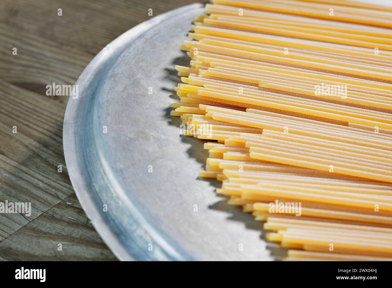 Espagueti de pasta seca sobre la mesa, preparación de alimentos, comida italiana tradicional Foto de stock