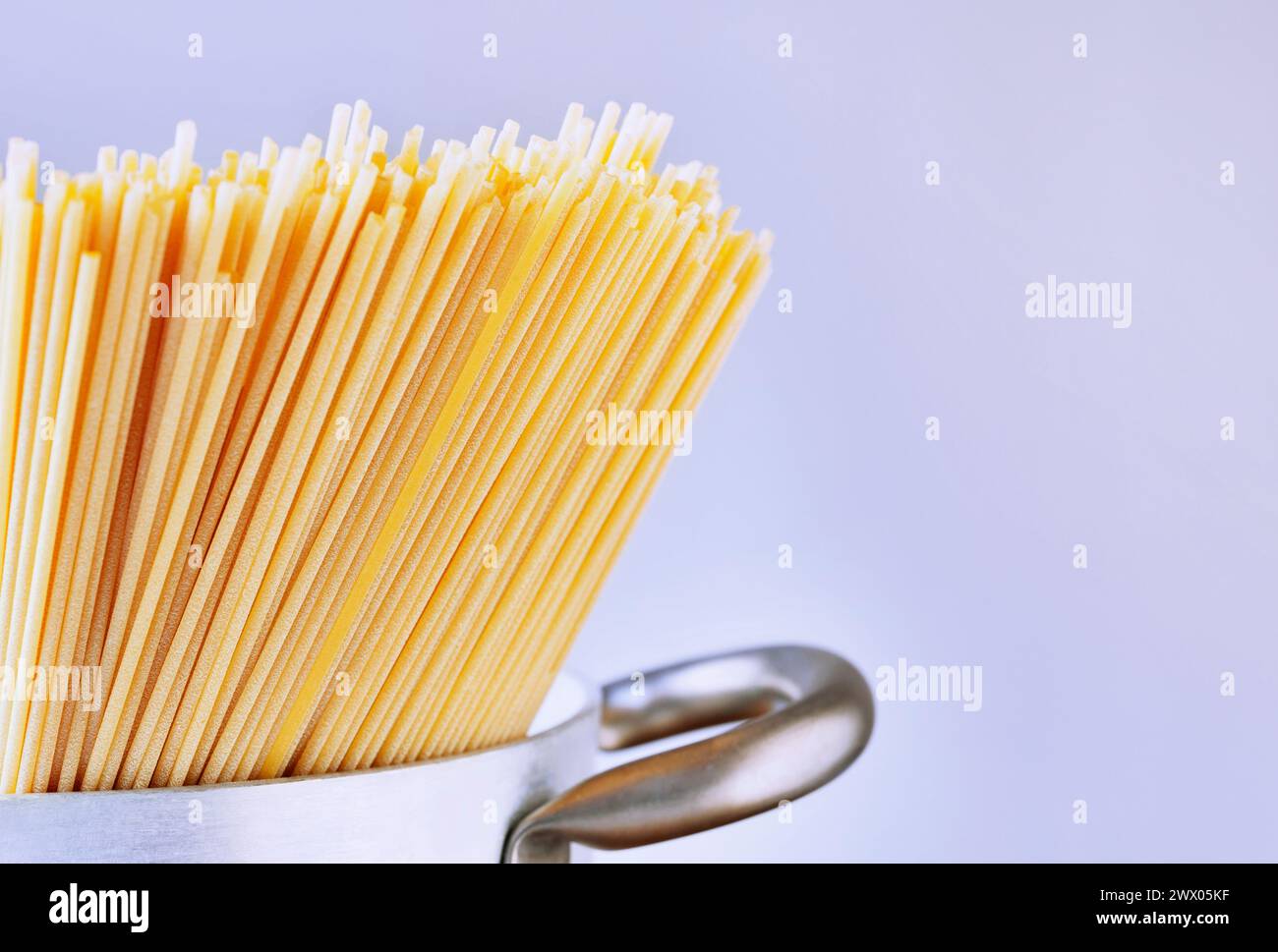 Espaguetis de pasta seca en sartén, preparación de comida, comida italiana tradicional Foto de stock