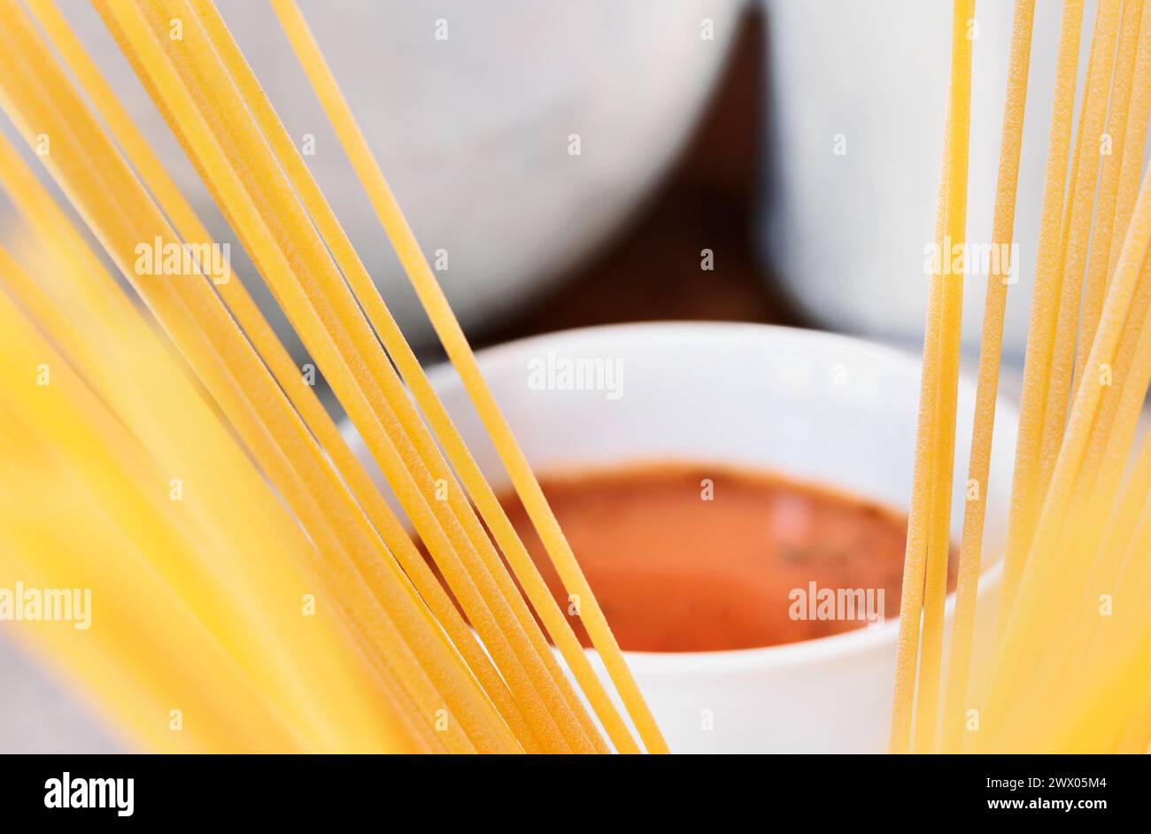 Espaguetis de pasta sin cocinar y salsa de tomate, preparando comida italiana tradicional Foto de stock