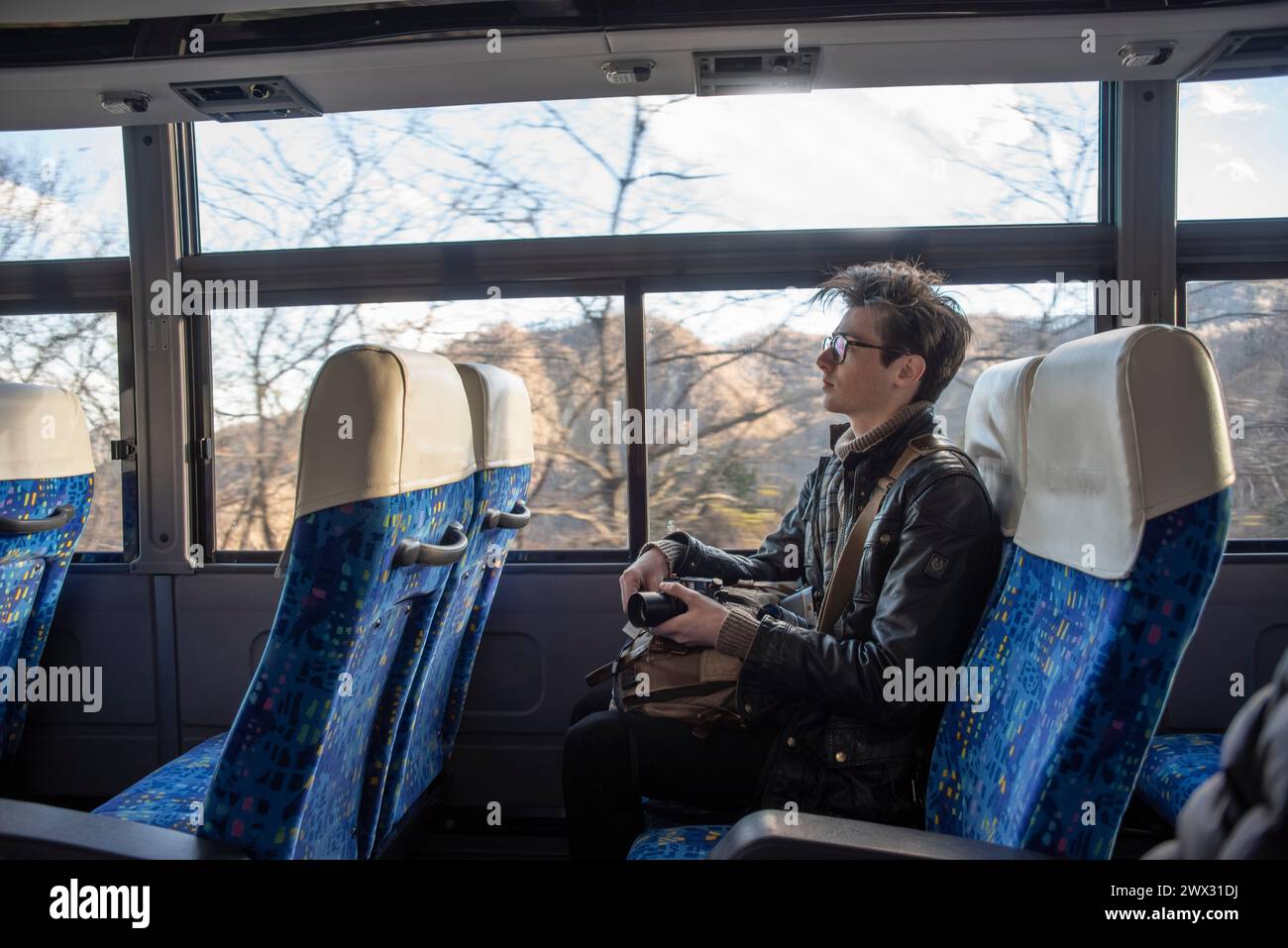Un joven viajando en un autobús en Japón. Foto de stock