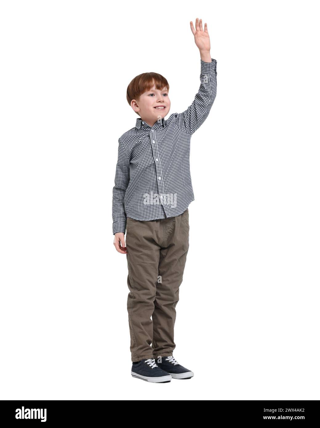 Niño pequeño sonriente agitando la mano sobre fondo blanco Foto de stock