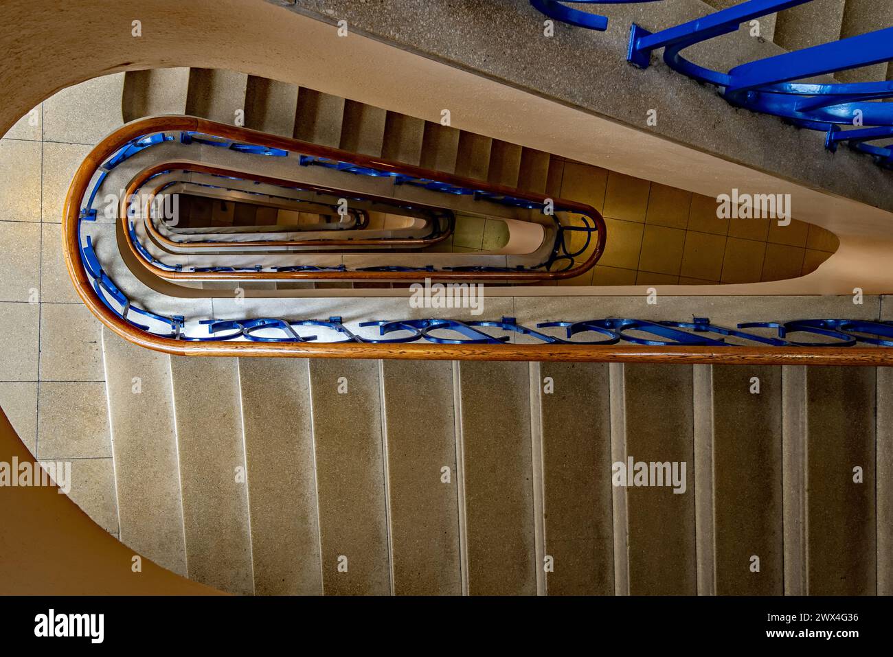 Una escalera de caracol desciende con gracia hacia abajo Foto de stock