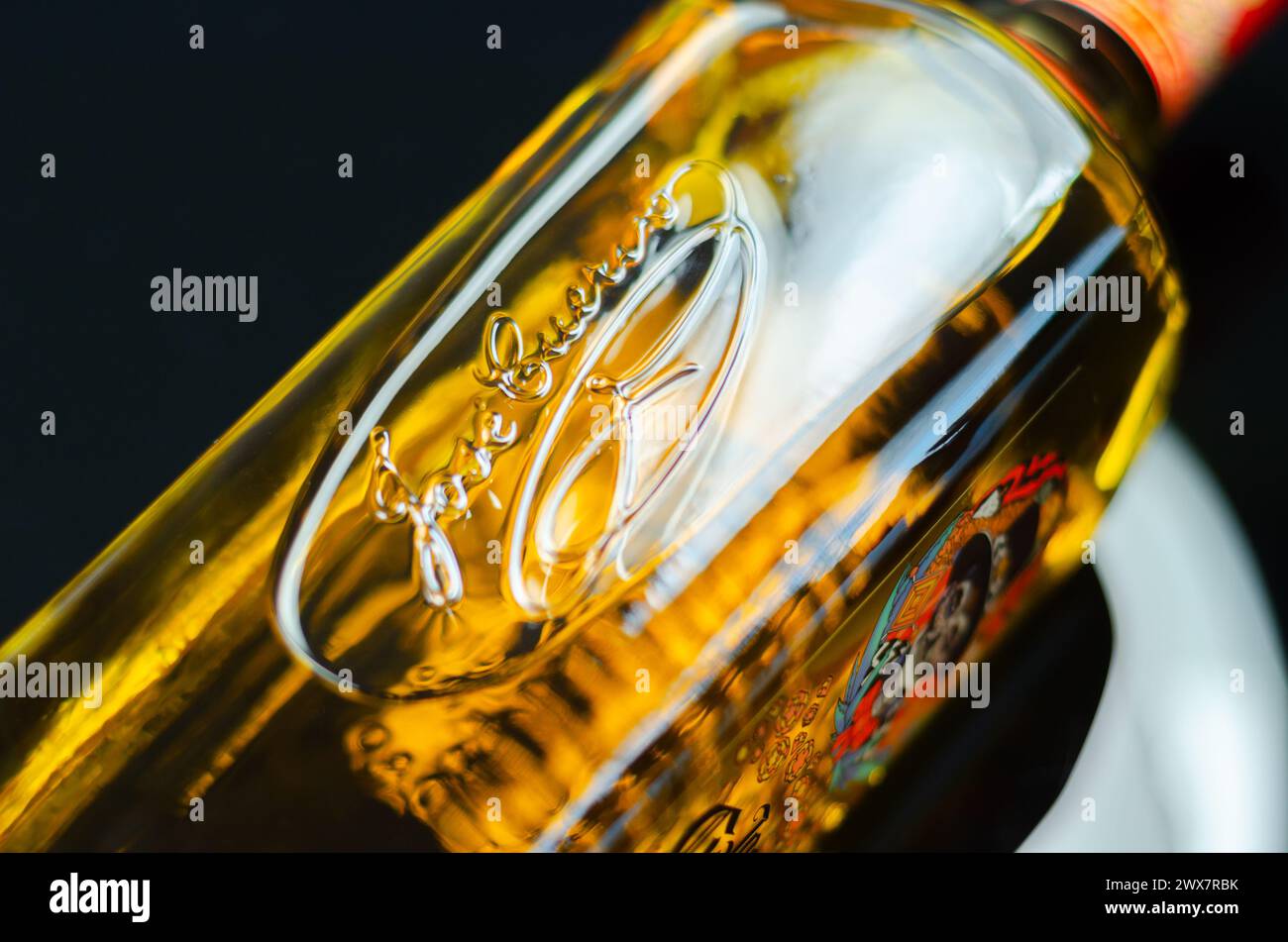 LONDRES, Reino Unido - 08 DE MARZO de 2024 Una botella de tequila reposado tradicional diseñada por el artista mexicano Pogo con un clásico motivo de cráneo realzado con ma naranja Foto de stock