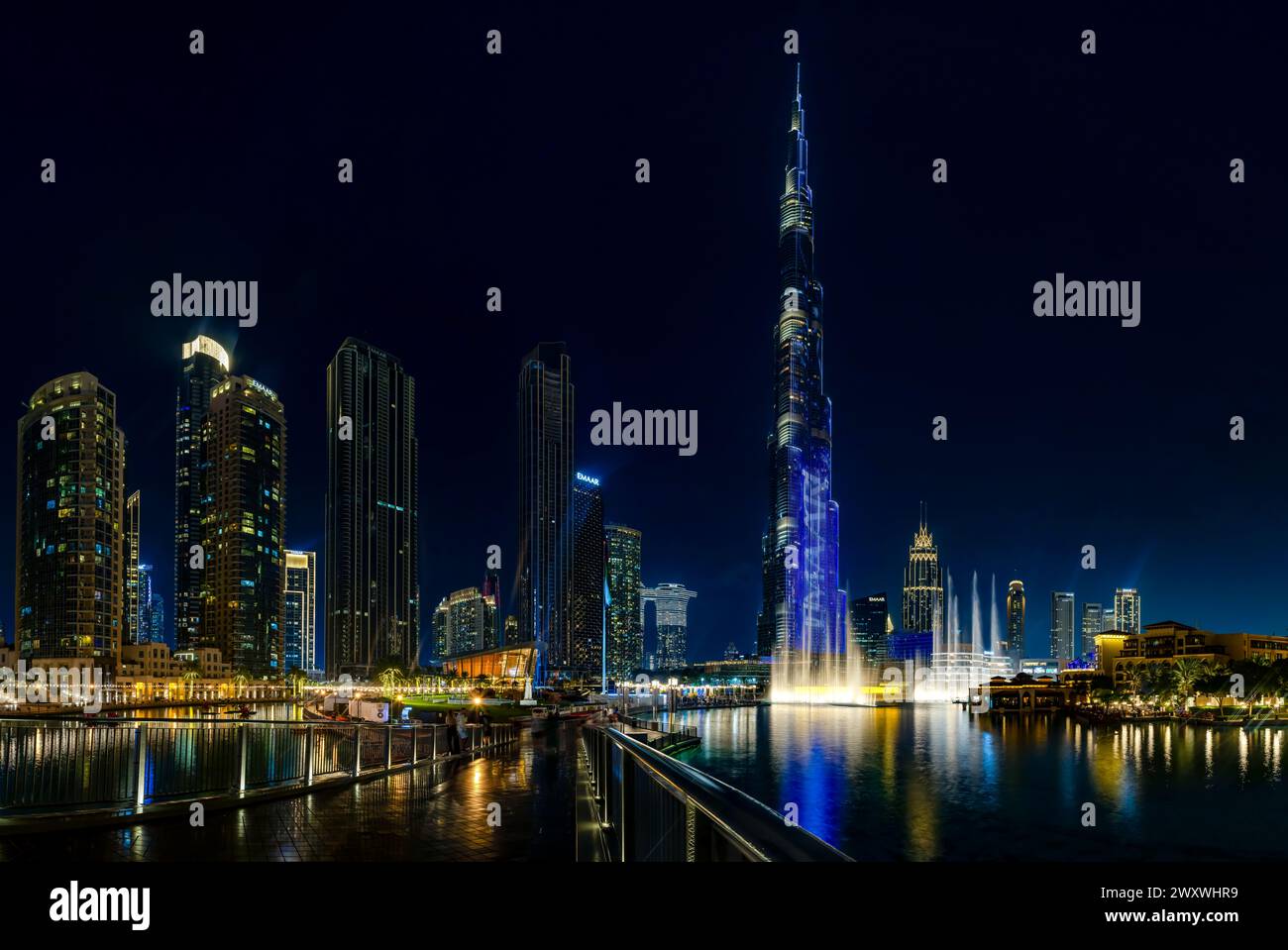 Una imagen del icónico Burj Khalifa con el Dubai Fountain Show, y los edificios del centro de Dubai y el lago Burj Khalifa, en la noche. Foto de stock