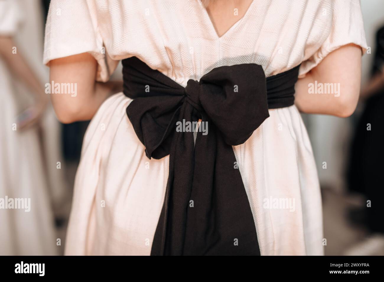 Detalles de moda femenina elegante vestido beige primavera verano con gran lazo negro en la parte posterior Foto de stock