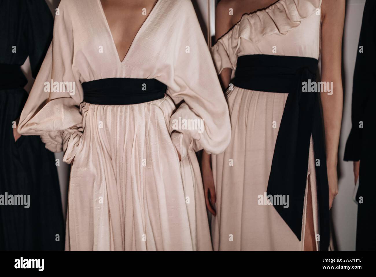 Elegantes detalles de moda femenina de primavera verano beige vestidos largos con cinturones anchos negros Foto de stock