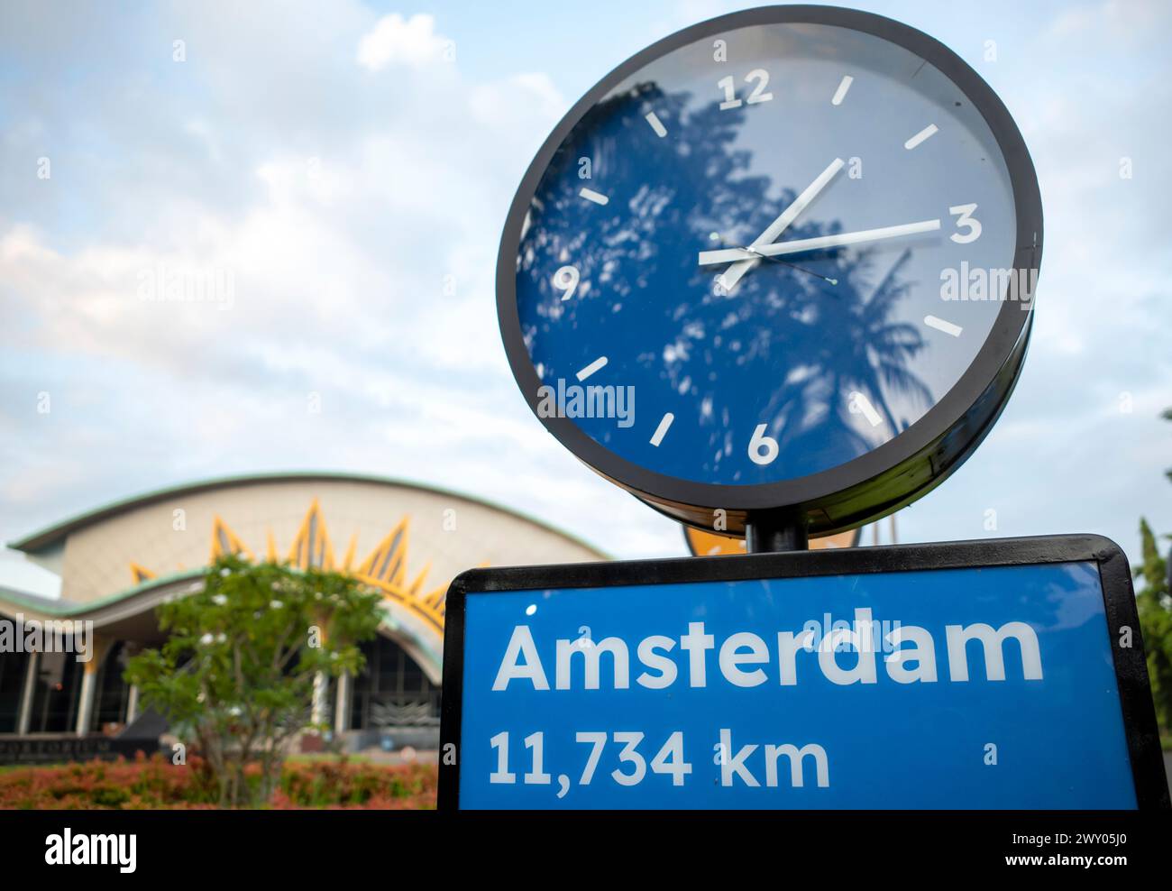 Un cartel de tráfico azul de Ámsterdam y un reloj público azul, a 11754 km de Ámsterdam. Foto de stock