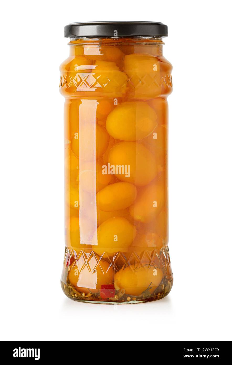 Tomates en un frasco, deliciosos tomates amarillos en escabeche en un frasco de vidrio aislado en blanco con trazado de recorte Foto de stock