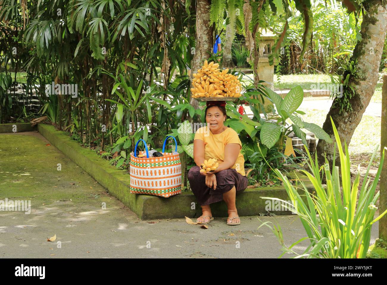 Bali en Indonesia - 31 de enero de 2024: Una señora que vende frutas de plátano Foto de stock