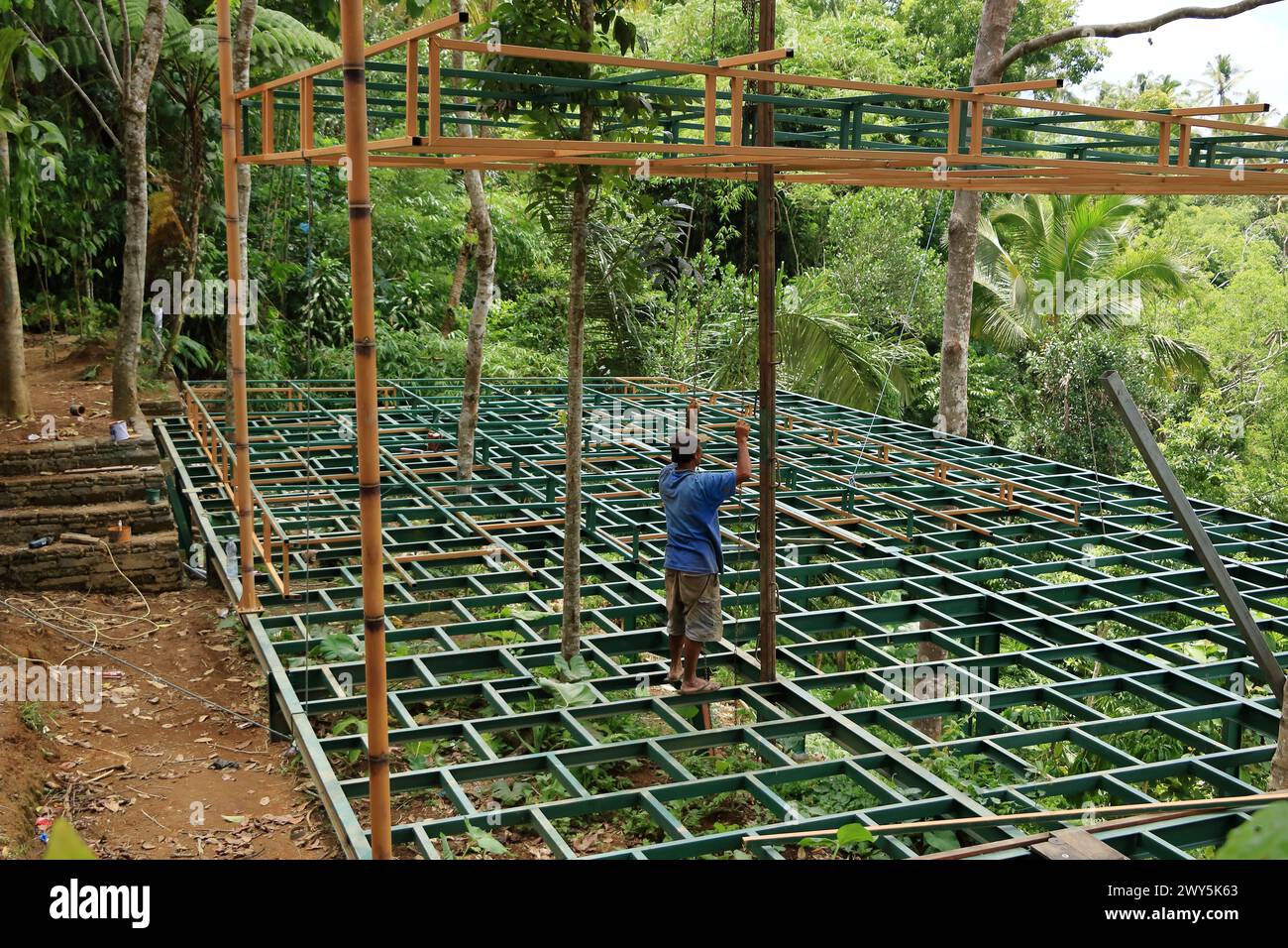 Bali en Indonesia - 31 de enero de 2024: Hombres locales, trabajadores de la construcción que arreglan un nuevo techo Foto de stock