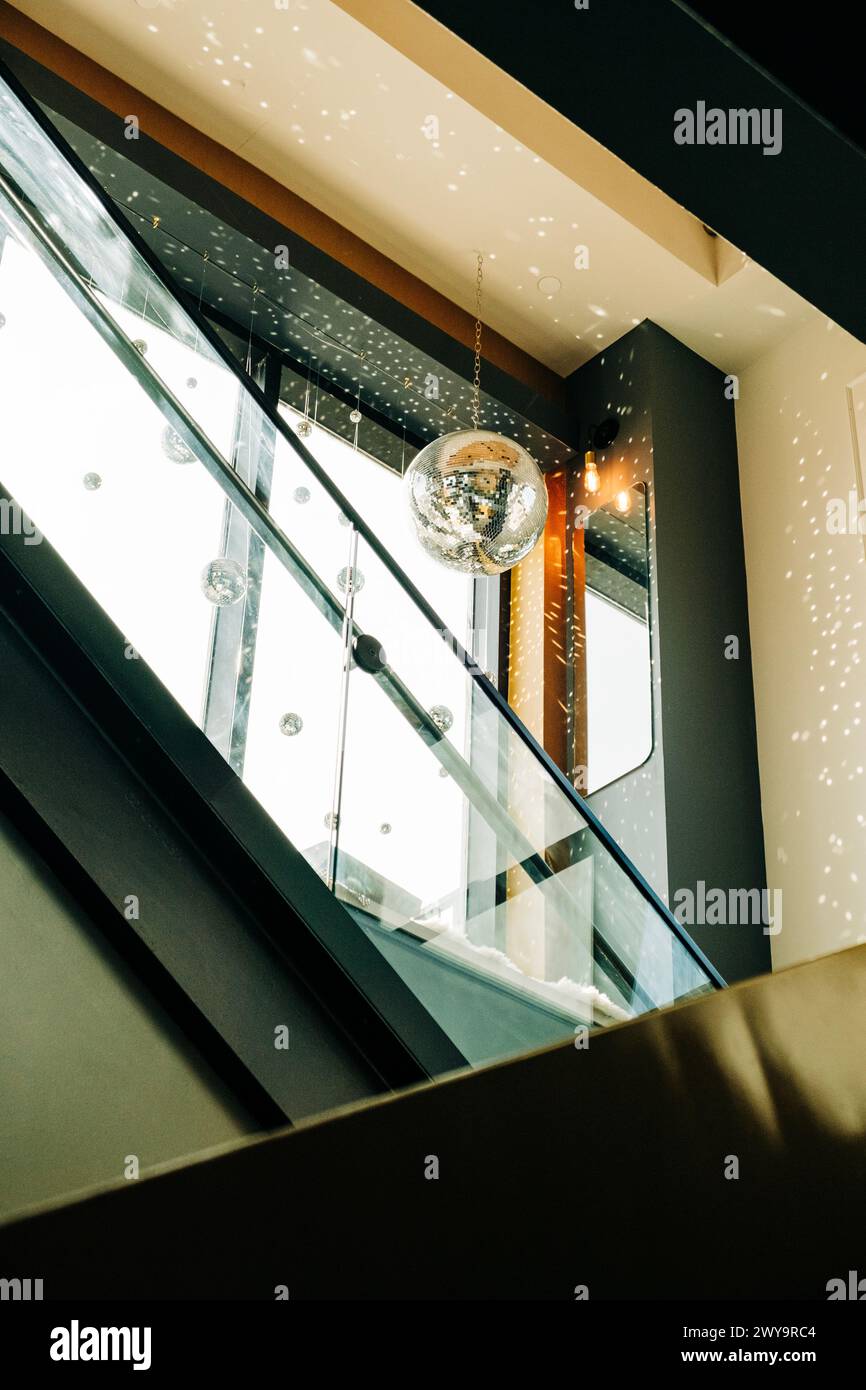 Moderna escalera mecánica con una bola de disco en un edificio Foto de stock