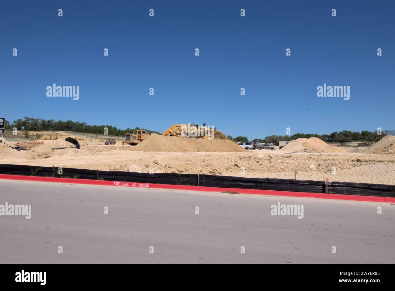 Equipos de excavación que nivelan colinas en Texas Hill Country para apoyar la expansión urbana, que muchos ven como una transformación negativa a la vida rural / ranchera. Foto de stock