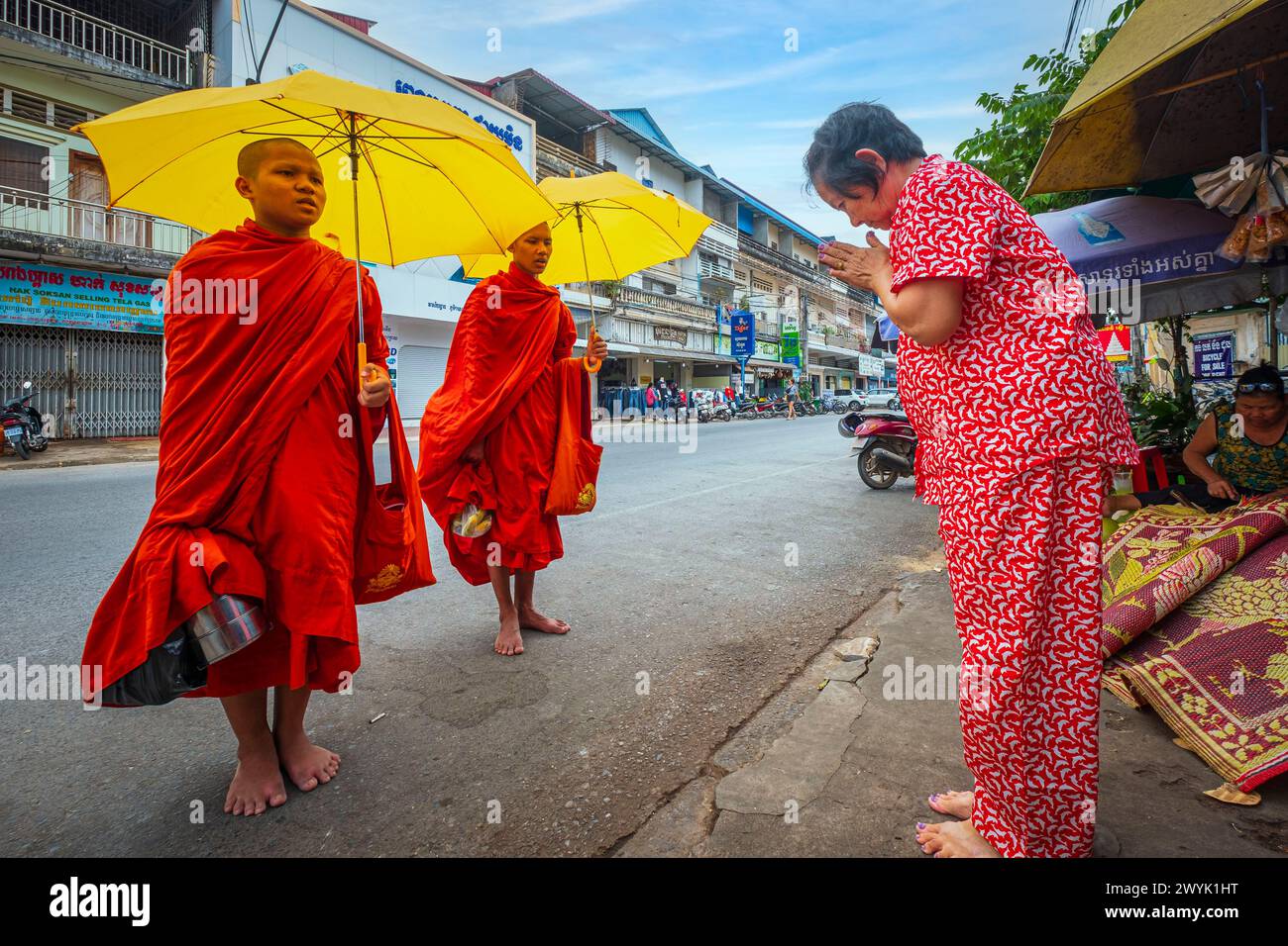 Camboya, provincia de Kampot, Kampot, jóvenes monjes budistas que reciben limosnas de los fieles cada mañana Foto de stock