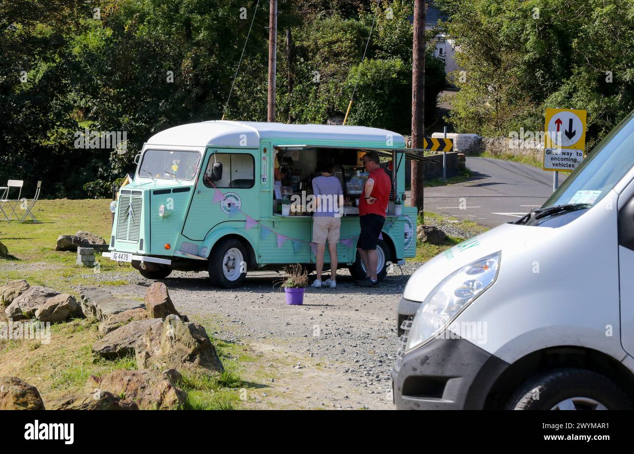 Los visitantes byuing café junto a la carretera Irlanda de la furgoneta de café barista vintage. Foto de stock