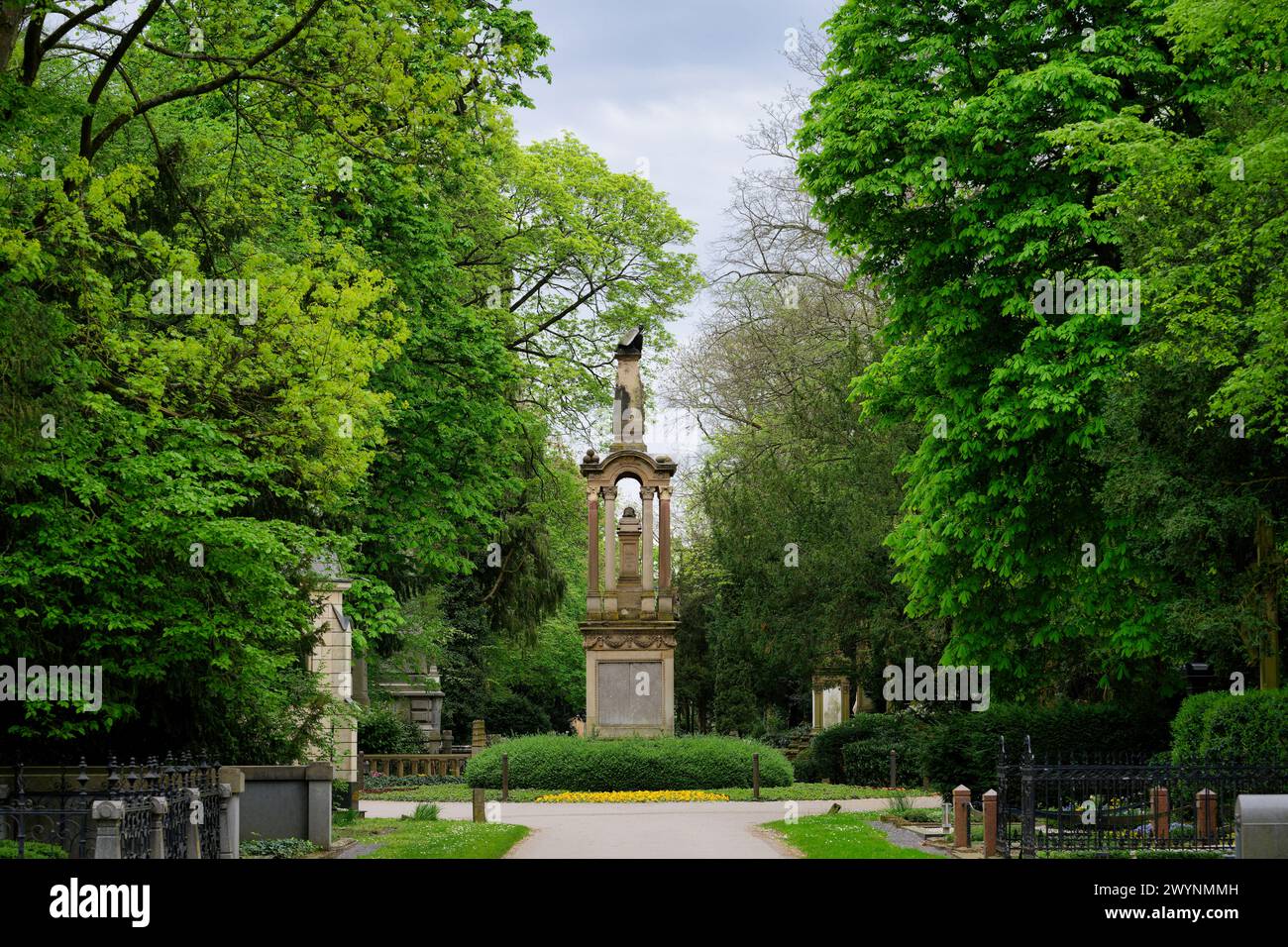 El histórico cementerio melaten en colonia con una vista de la columna central del águila en estado de ánimo primaveral Foto de stock