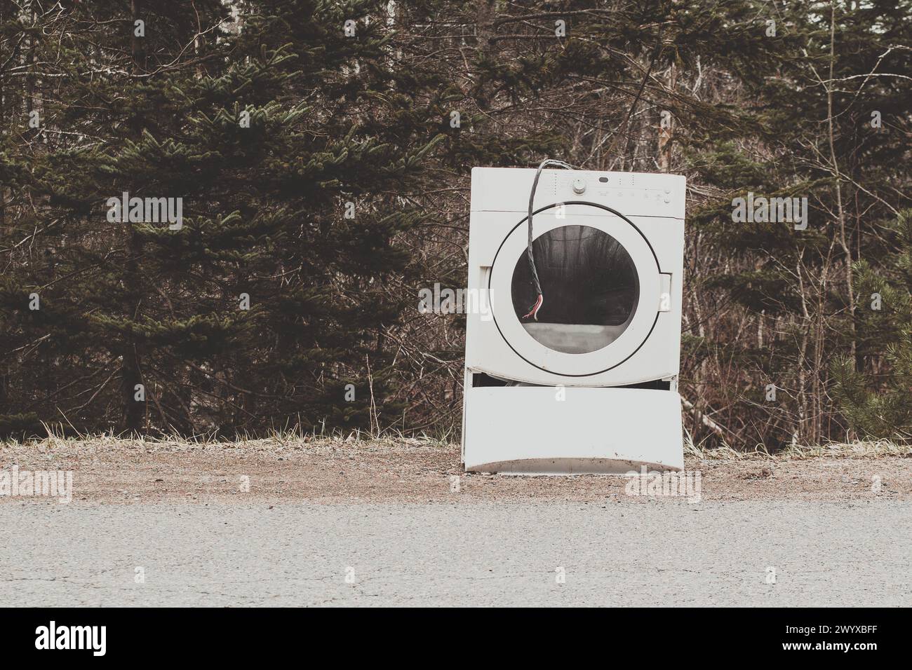 Secadora de ropa vieja y descartada en el lado de un camino rural Foto de stock
