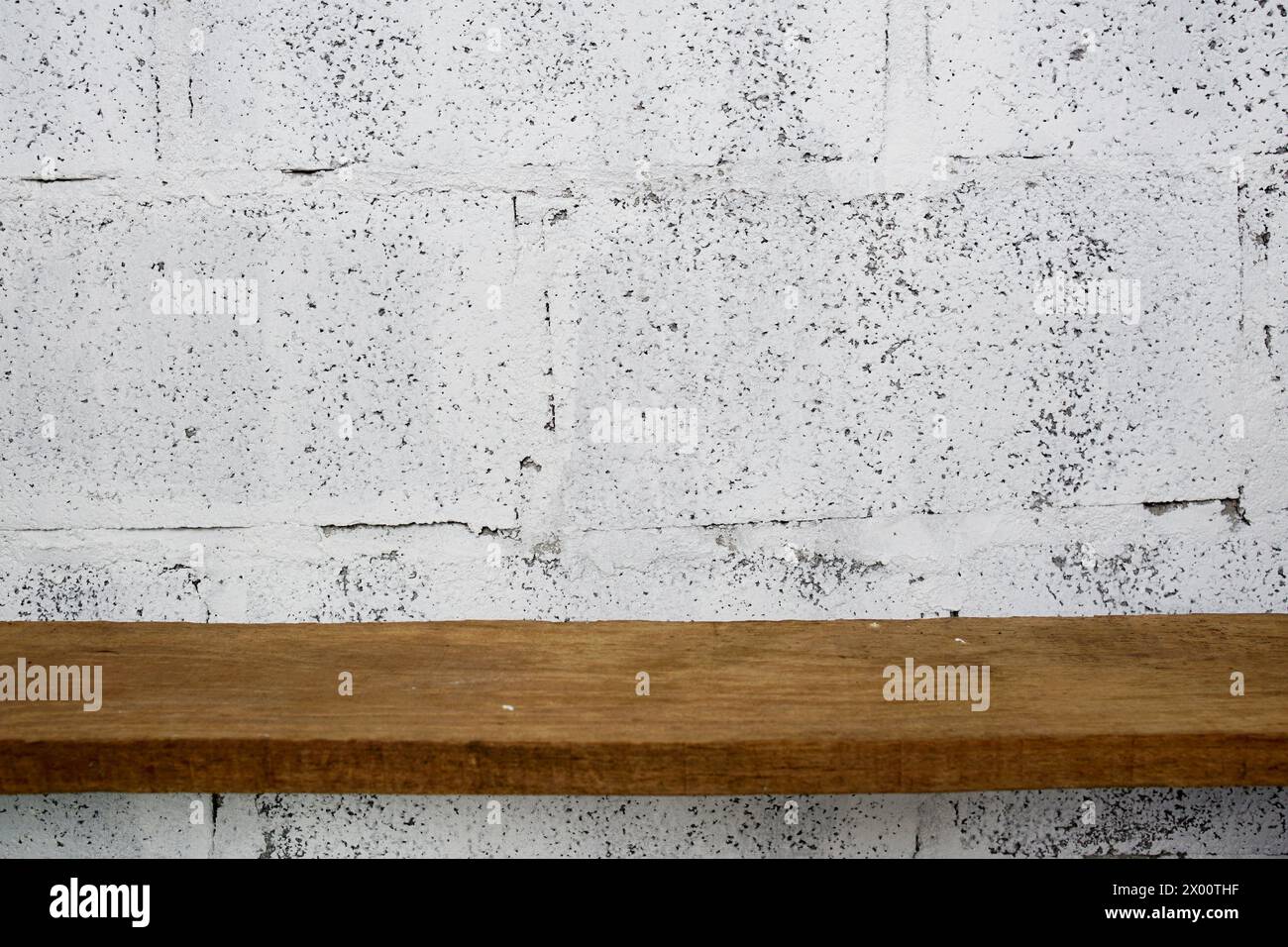 Estantes de madera sobre fondo de pared de hormigón blanco para la exhibición Foto de stock
