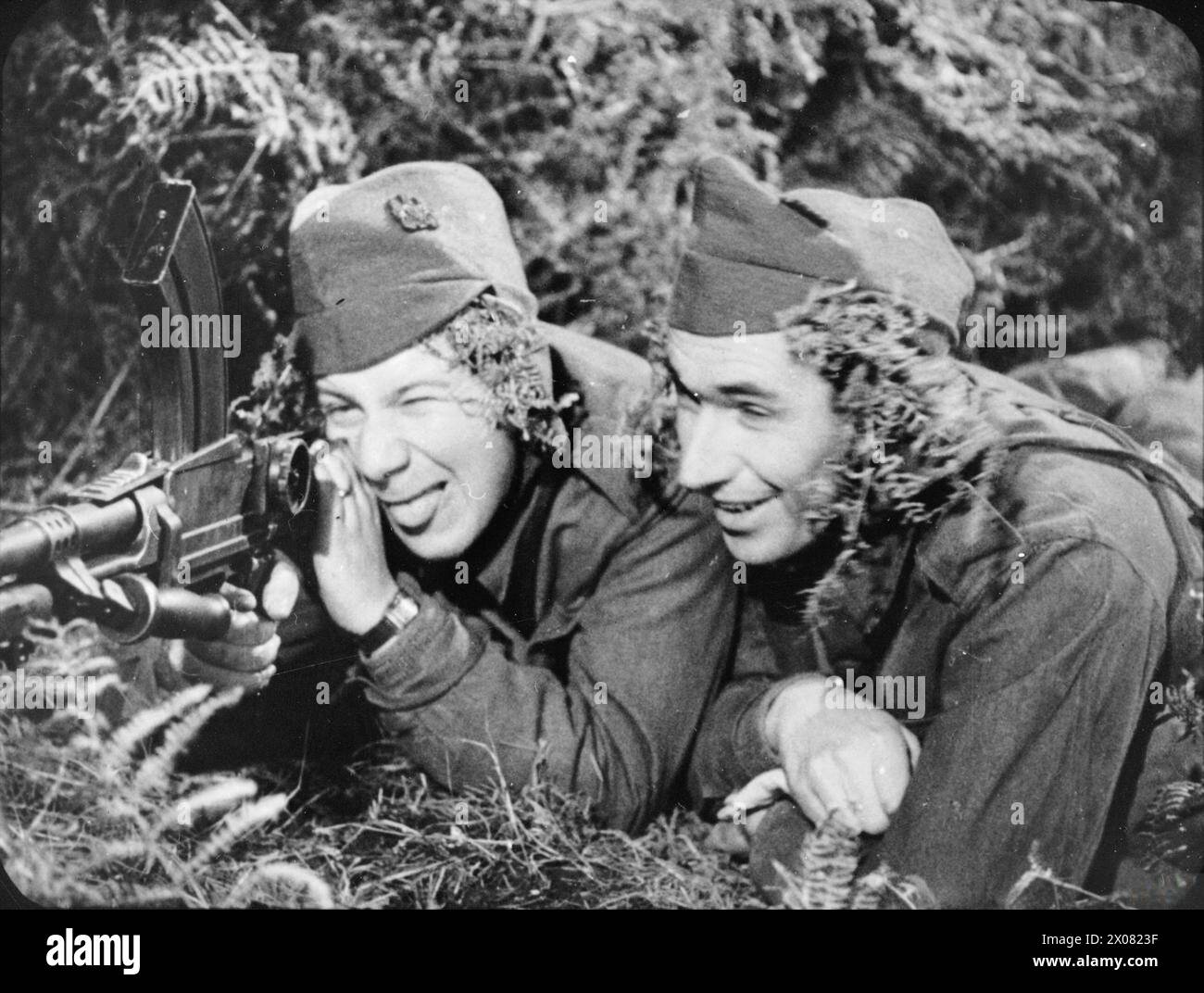 Blanco y negro - todavía de la película de entrenamiento del ejército británico de 1943 'The New Lot' (DRA 443).'Ted' (Bernard Miles) y 'Keith' (Peter Ustinov) pusieron su entrenamiento con armas de guerra a buen uso Foto de stock