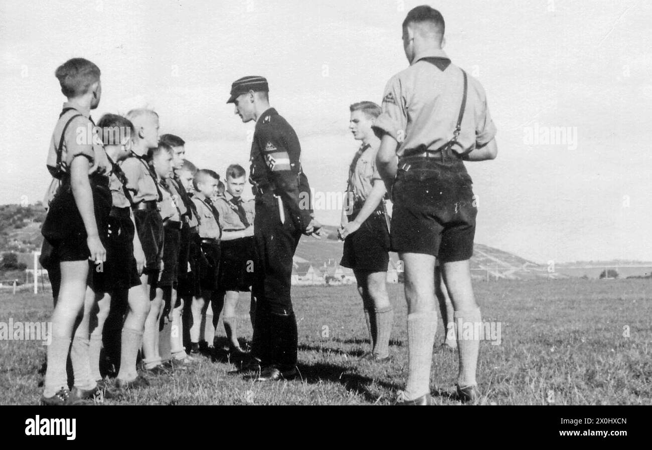 Ver más sobre Hitlerjugend stehen aufgereiht vor einem (vermutlichen) Reichsjugendführer, der ihnen Befehle erteilt. (Aufnahmedatum: 01.01.1933-31.12.1945) Foto de stock