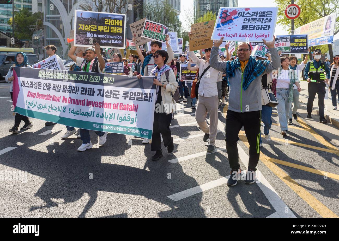 Seúl, Corea del Sur. 13 de abril de 2024. Los partidarios pro-palestinos sostienen una pancarta y pancartas durante una protesta en el centro de Seúl. ¡Los partidarios pro-palestinos marcharon en el centro de Seúl pidiendo el fin del genocidio ahora! ¡Y ninguna invasión terrestre de Rafah!. Crédito: SOPA Images Limited/Alamy Live News Foto de stock