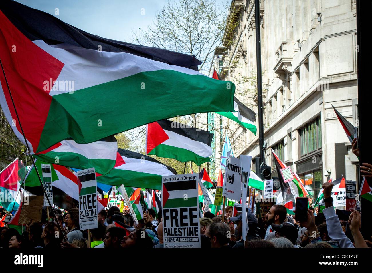 Londres, Reino Unido. 13 de abril de 2024. Manifestantes sostienen banderas palestinas durante la marcha Palestina: Dejen de armar a Israel. Los londinenses se unieron al día nacional de acción por Palestina mientras marchaban a la Plaza del Parlamento para exigir que el gobierno del Reino Unido deje de armar a Israel y exija un alto el fuego permanente. Crédito: SOPA Images Limited/Alamy Live News Foto de stock