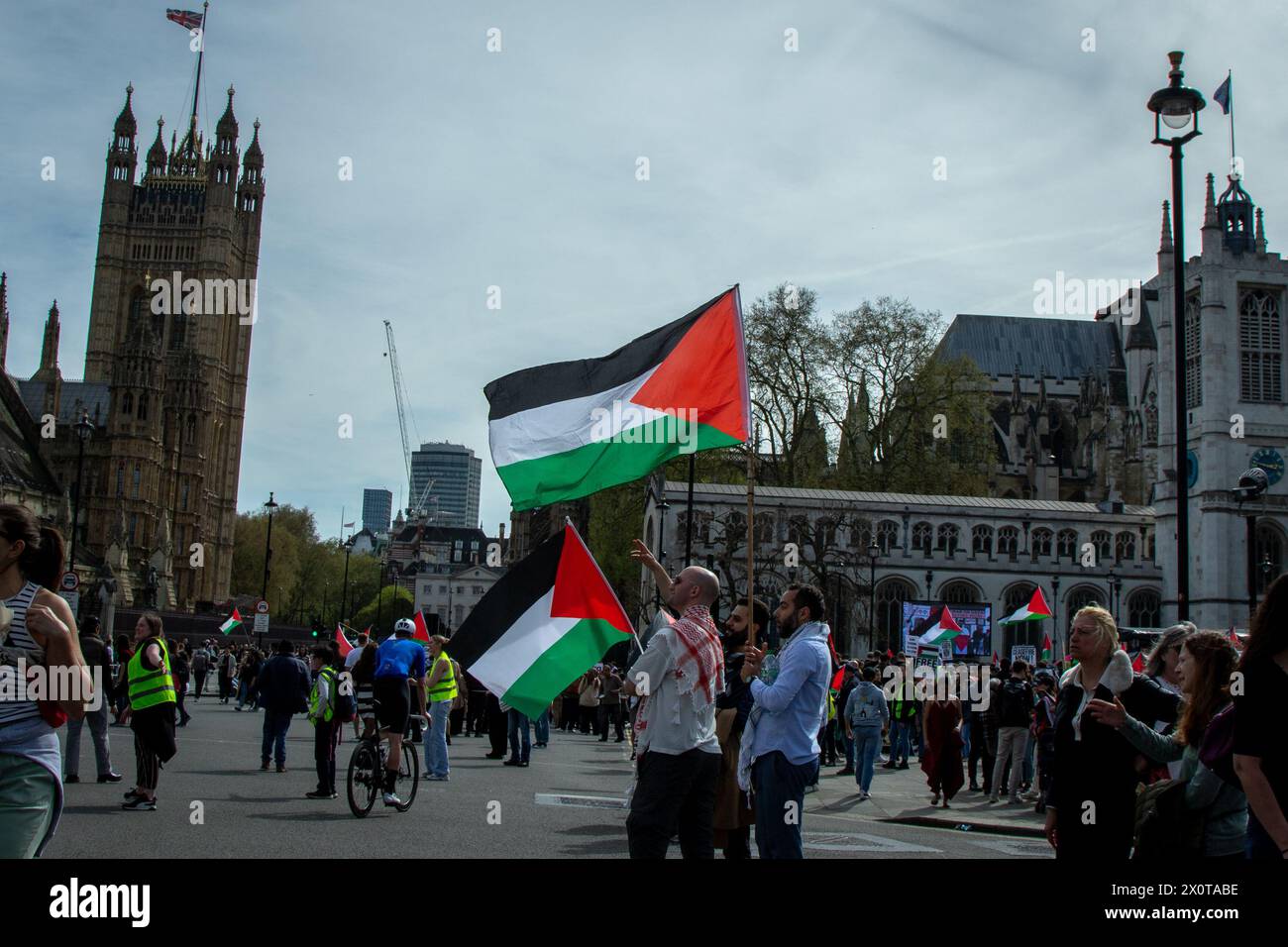 Londres, Reino Unido. 13 de abril de 2024. Manifestantes sostienen banderas palestinas durante la marcha Palestina: Dejen de armar a Israel. Los londinenses se unieron al día nacional de acción por Palestina mientras marchaban a la Plaza del Parlamento para exigir que el gobierno del Reino Unido deje de armar a Israel y exija un alto el fuego permanente. Crédito: SOPA Images Limited/Alamy Live News Foto de stock