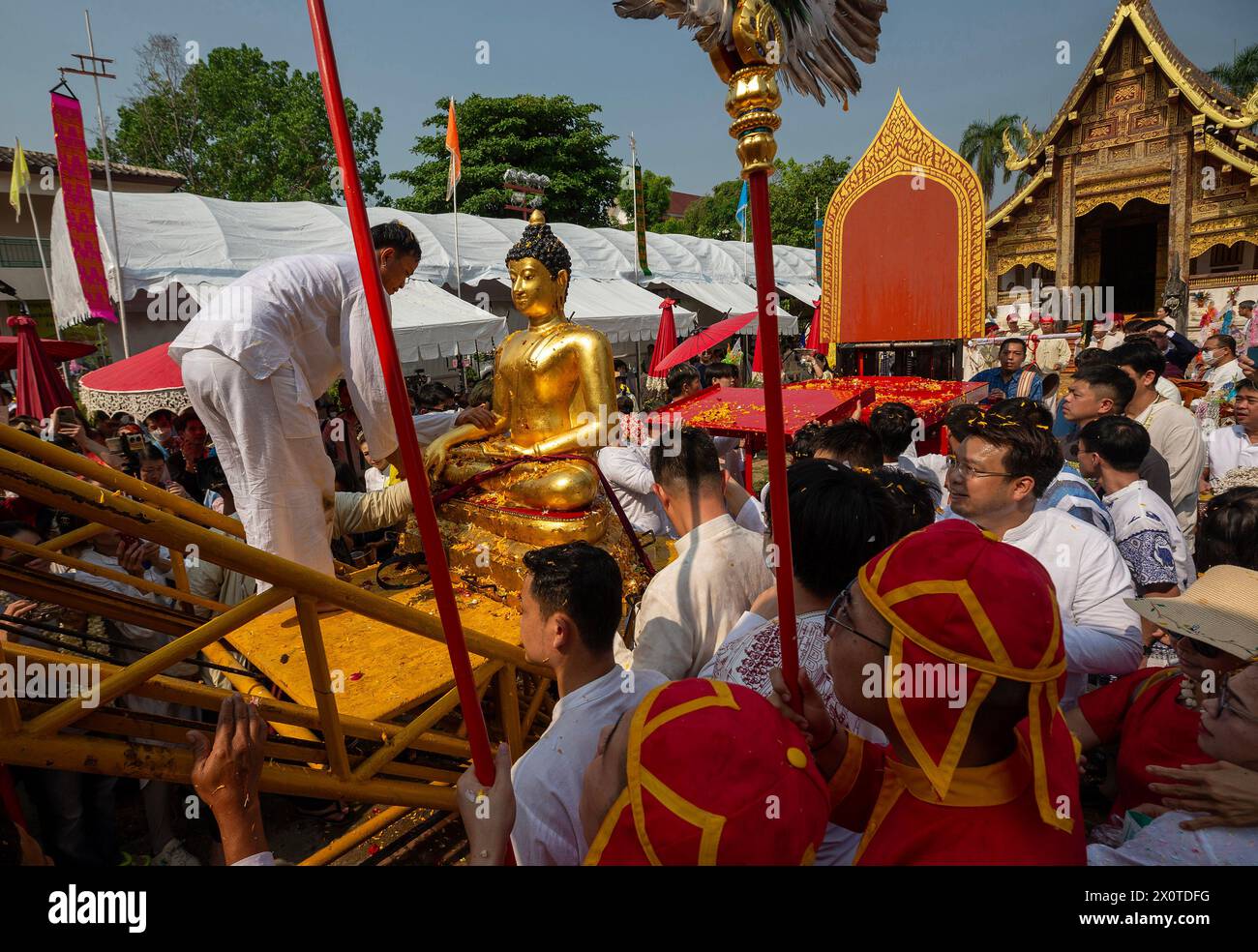 Los tailandeses vistiendo trajes tradicionales vistos durante la procesión de la estatua del Buda Phra Sihing para conmemorar las celebraciones de Songkran en el templo Wat Phra Singh Woramahaviharn. La fiesta de Songkran también se conoce como el festival del agua que se celebra anualmente el día tradicional de Año Nuevo tailandés el 13 de abril, pulverizando agua y arrojando polvo entre sí, como un signo simbólico de limpieza y lavado de los pecados del año pasado. Foto de stock