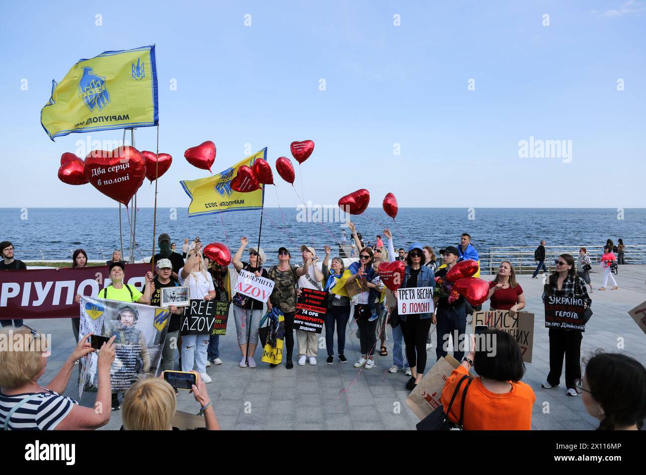 Odessa, Ucrania. 14 de abril de 2024. Los manifestantes sostienen pancartas que expresan su opinión durante la manifestación en la playa de Langeron. En la playa de Lanzheron se celebró una manifestación “No sean silenciosos las muertes en cautiverio”, cuya esencia era llamar la atención del público y las autoridades sobre los prisioneros que se encuentran en la Federación Rusa. Crédito: SOPA Images Limited/Alamy Live News Foto de stock