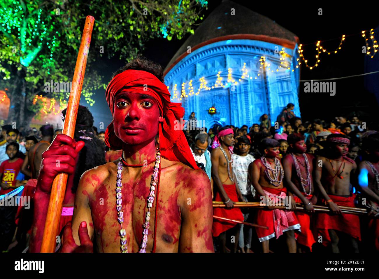 Un devoto hindú con su cara de color rojo posa para una foto durante el festival anual de Gajan. Gajan es un festival hindú celebrado principalmente en la parte rural de Bengala Occidental. El festival está relacionado con el Señor Shiva y según la mitología en el último día del Calendario Bengalí (mediados de abril) los devotos solían adorar a los cadáveres para satisfacer al Señor Shiva para una mejor lluvia y cosecha según las prácticas tradicionales de 100 años de antigüedad. El tema central de este festival es obtener satisfacción a través del dolor no sexual, la devoción y el sacrificio. Foto de stock
