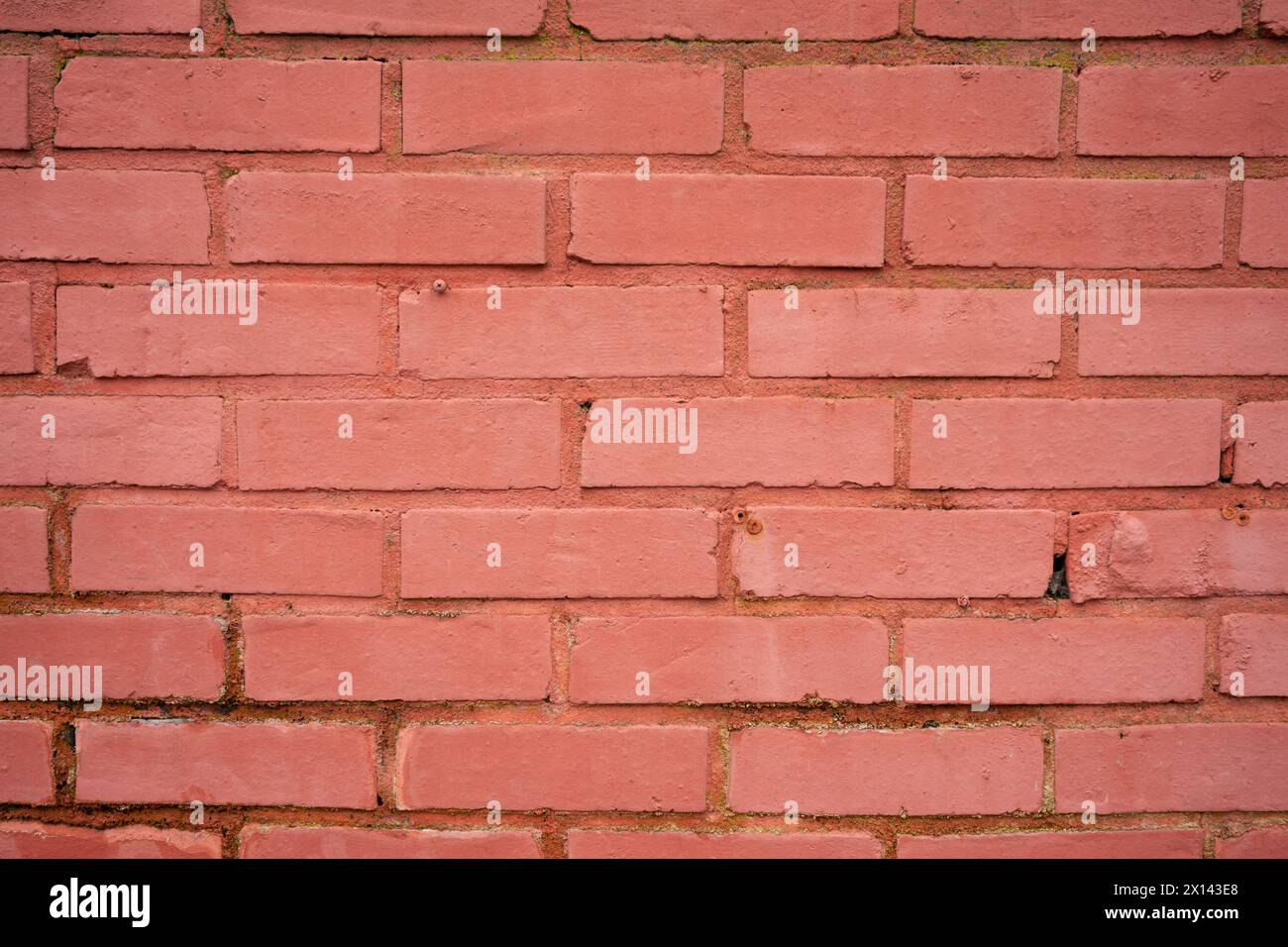 Una pared de ladrillo rojo a la luz del día y un cielo nublado. Foto de stock