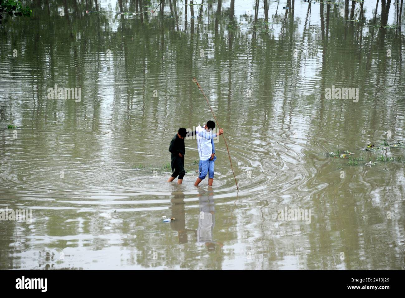 Peshawar, Peshawar, Pakistán. 15 de abril de 2024. Las condiciones climáticas extremas causan víctimas en Pakistán.PESHAWAR, PAKISTÁN - 15 DE ABRIL: La gente observa las inundaciones en el río Charsadda debido a las fuertes lluvias en Peshawar, Pakistán el 15 de abril de 2024. Según la Autoridad Provincial de Gestión de Desastres de Khyber Pakhtunkhwa (KP), al menos 29 personas han muerto y otras siete han resultado heridas. En los últimos tres días, varias provincias se vieron afectadas por incidentes relacionados con rayos y fuertes lluvias. (Imagen de crédito: © Hussain Ali/ZUMA Press Wire) USO EDITORIAL SOLAMENTE! No para USO comercial! Foto de stock