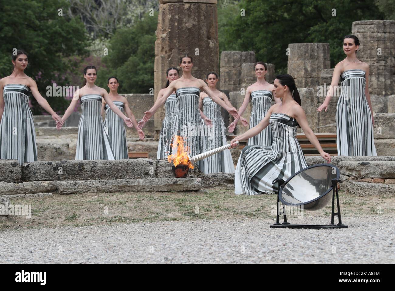 Antigua Olimpia, Grecia. 16 de abril de 2024. La actriz Mary Mina, en el papel de una antigua Suma Sacerdotisa griega, enciende la antorcha durante la ceremonia olímpica de iluminación de llama para los Juegos Olímpicos de Verano de París 2024 en la Antigua Olimpia, Grecia, el 16 de abril de 2024. Crédito: Li Jing/Xinhua/Alamy Live News Foto de stock