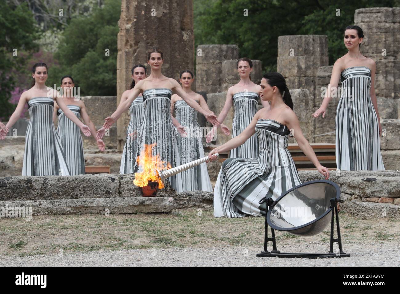 Antigua Olimpia, Grecia. 16 de abril de 2024. La actriz Mary Mina, en el papel de Suma Sacerdotisa, enciende la antorcha durante la ceremonia de iluminación de llama olímpica para los Juegos Olímpicos de Verano de París 2024 en la Antigua Olimpia, Grecia, el 16 de abril de 2024. Crédito: Li Jing/Xinhua/Alamy Live News Foto de stock