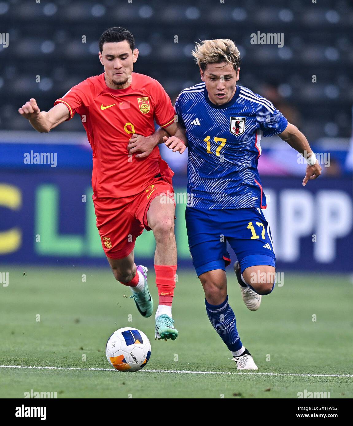 Doha, Qatar. 16 de abril de 2024. Behram Abduweli (Izq) de China compite con Matsuki Kuryu de Japón durante el partido de fútbol Grupo B entre China y Japón de la Copa Asiática AFC Sub-23 Qatar 2024 en el estadio Jassim Bin Hamad en Doha, Qatar, el 16 de abril de 2024. Crédito: Nikku/Xinhua/Alamy Live News Foto de stock