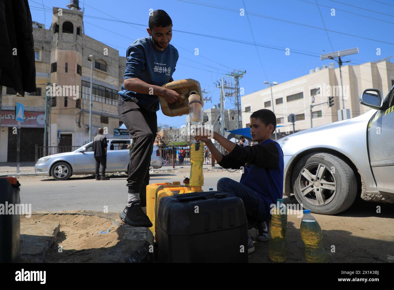 Gaza. 16 de abril de 2024. La gente llena contenedores con combustible en la ciudad de Deir el-Balah, en el centro de la Franja de Gaza, 16 de abril de 2024. Crédito: Rizek Abdeljawad/Xinhua/Alamy Live News Foto de stock