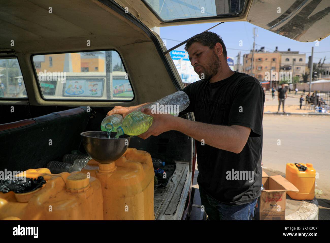 Gaza. 16 de abril de 2024. Un hombre llena latas de petróleo con combustible en la ciudad de Deir el-Balah, en el centro de la Franja de Gaza, el 16 de abril de 2024. Crédito: Rizek Abdeljawad/Xinhua/Alamy Live News Foto de stock