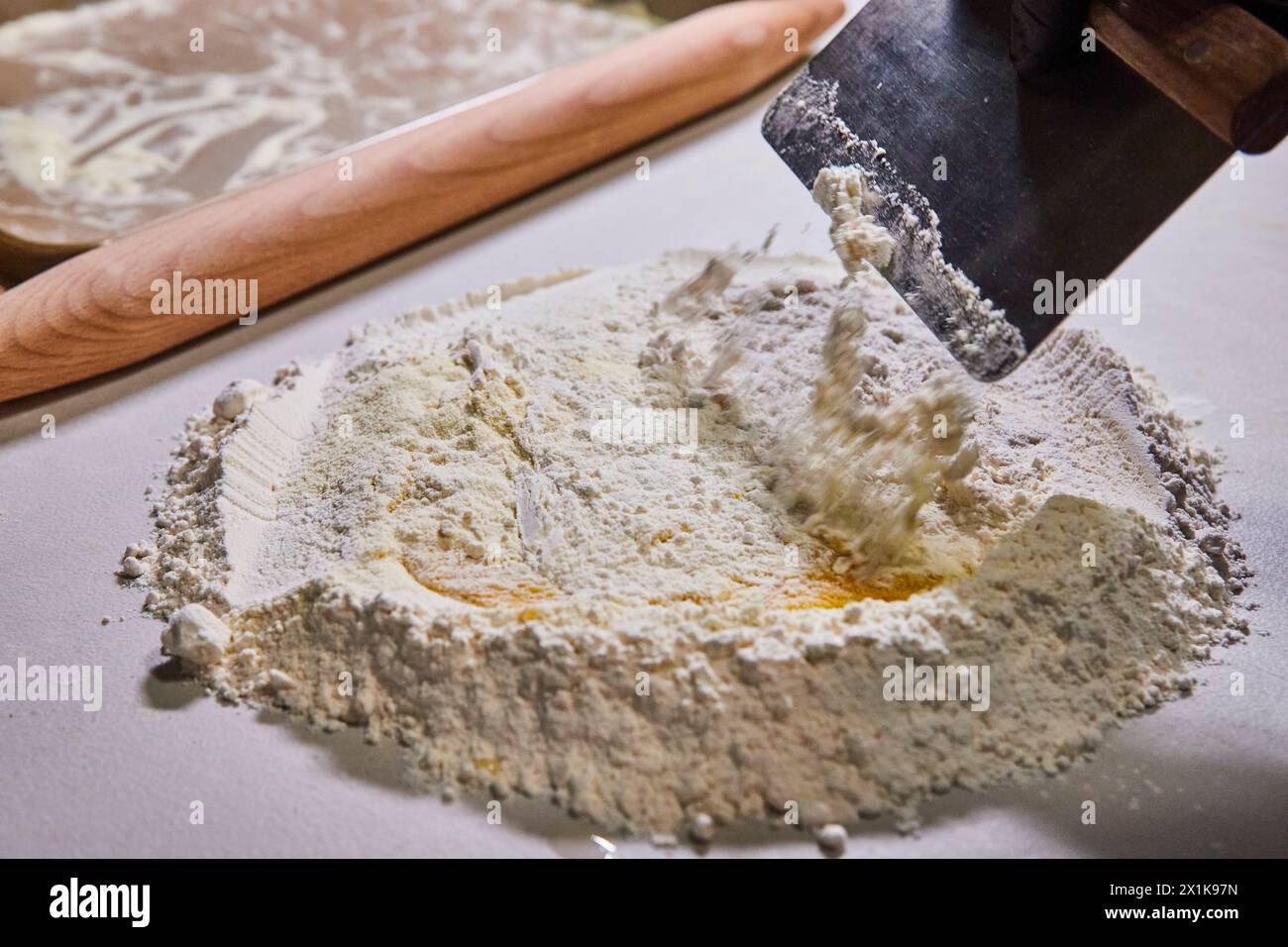 Preparación de pasta artesanal con huevo y harina, primer plano de rascador de masa Foto de stock