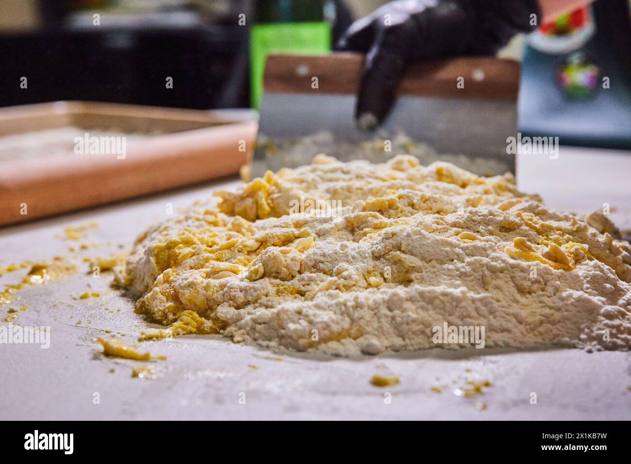 Preparación de masa artesanal, manos enguantadas con rascador - Cocina Primer plano Foto de stock