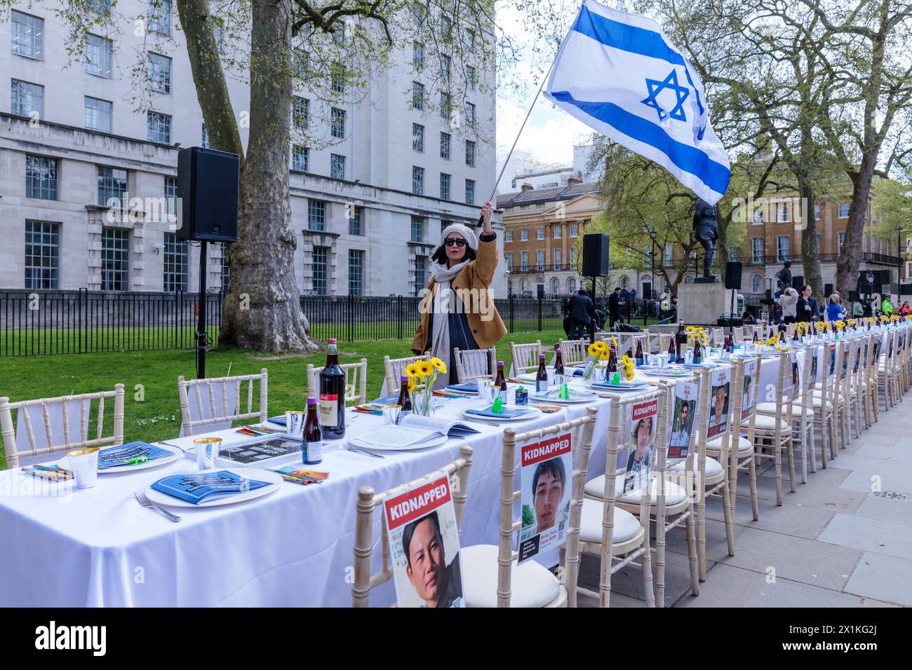 Richmond Terrace, Londres, Reino Unido. El Foro de familias de rehenes del Reino Unido presenta 'La mesa vacía del Seder'. En Whitehall, frente a Downing Street. Esta instalación de 133 sillas desocupadas, cada una representando a uno de los rehenes que aún están en cautiverio, un conmovedor recordatorio de los individuos que permanecen separados de sus familias esta Pascua. Foto de Amanda Rose/Alamy Live News Foto de stock