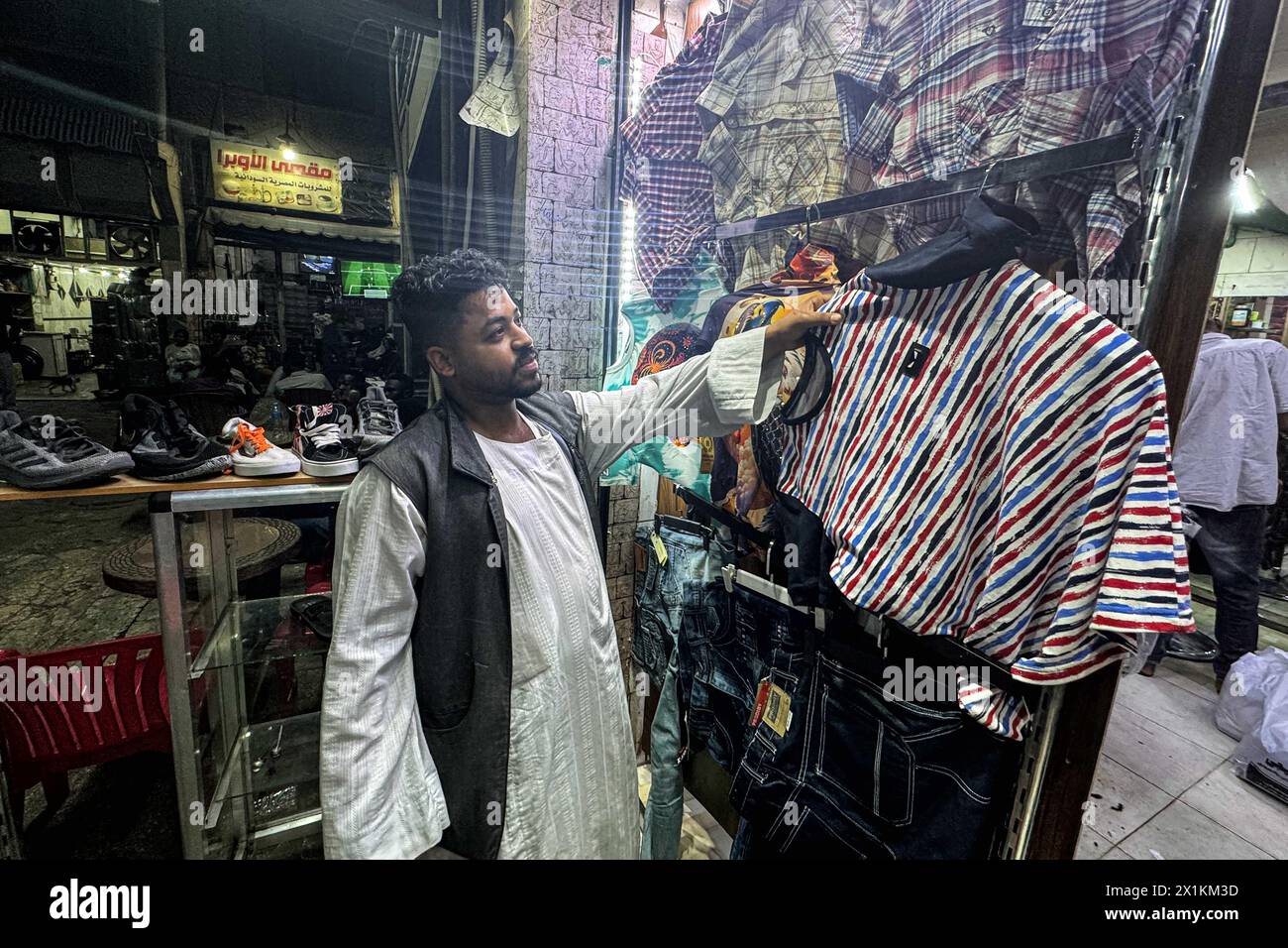 El Cairo, Egipto. 16 de abril de 2024. Un sudanés vende ropa en el barrio de Al-Sufi en el centro de El Cairo, Egipto, el 16 de abril de 2024. Desde el estallido del conflicto hace un año, más de 500.000 sudaneses han huido a Egipto, según cifras publicadas por el Ministerio de Relaciones Exteriores de Egipto en marzo. PARA IR CON 'Característica: Sudaneses desplazados por el conflicto se esfuerzan por reconstruir vidas en Egipto' Crédito: Ahmed Gomaa/Xinhua/Alamy Live News Foto de stock