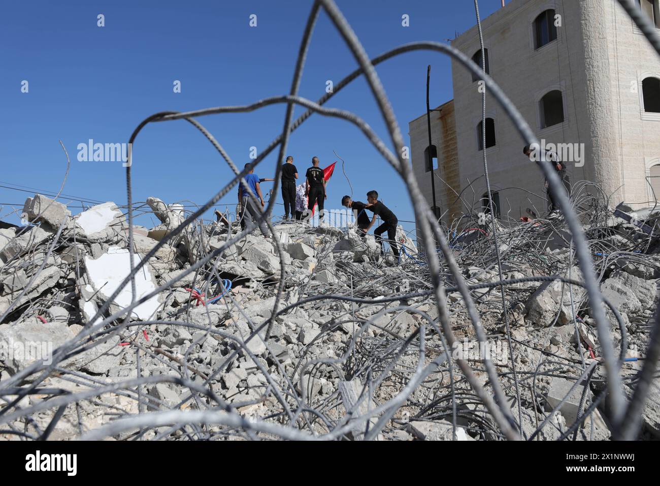 Hebrón. 17 de abril de 2024. La gente se reúne entre los escombros de una casa demolida por las fuerzas israelíes cerca de la ciudad de Hebrón, en Cisjordania, el 17 de abril de 2024. Crédito: Mamoun Wazwaz/Xinhua/Alamy Live News Foto de stock