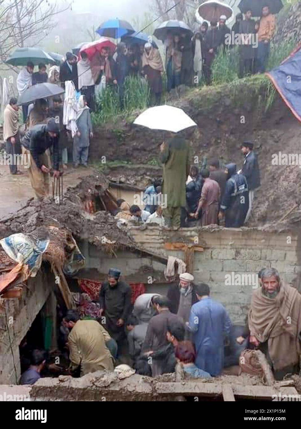Khyber Pakhtunkhwa. 16 de abril de 2024. Foto tomada con un teléfono móvil el 16 de abril de 2024 muestra a personas buscando sobrevivientes en casas dañadas por una fuerte lluvia en la provincia de Khyber Pakhtunkhwa, Pakistán. Las fuertes lluvias y los rayos causaron estragos en diferentes áreas de Pakistán, causando 71 muertos y heridos a otros 67 desde el sábado, dijo un funcionario a Xinhua el miércoles. Crédito: STR/Xinhua/Alamy Live News Foto de stock