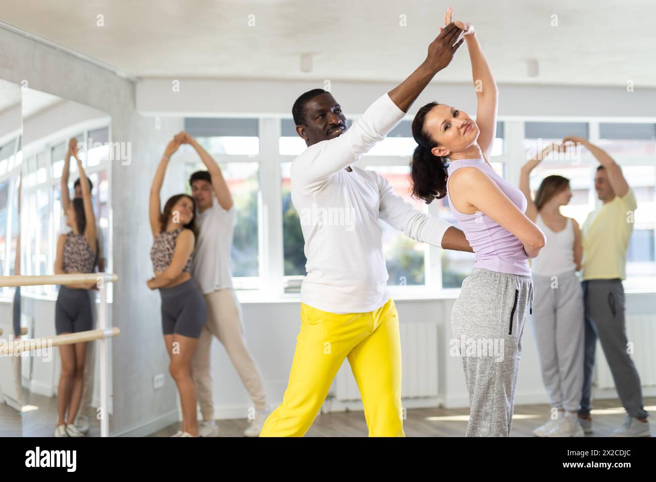 Hombres y mujeres están de pie uno al lado del otro y bailan en un par de  salsa. Los estudiantes practican los movimientos repetitivos de la danza de  pareja Fotografía de stock -