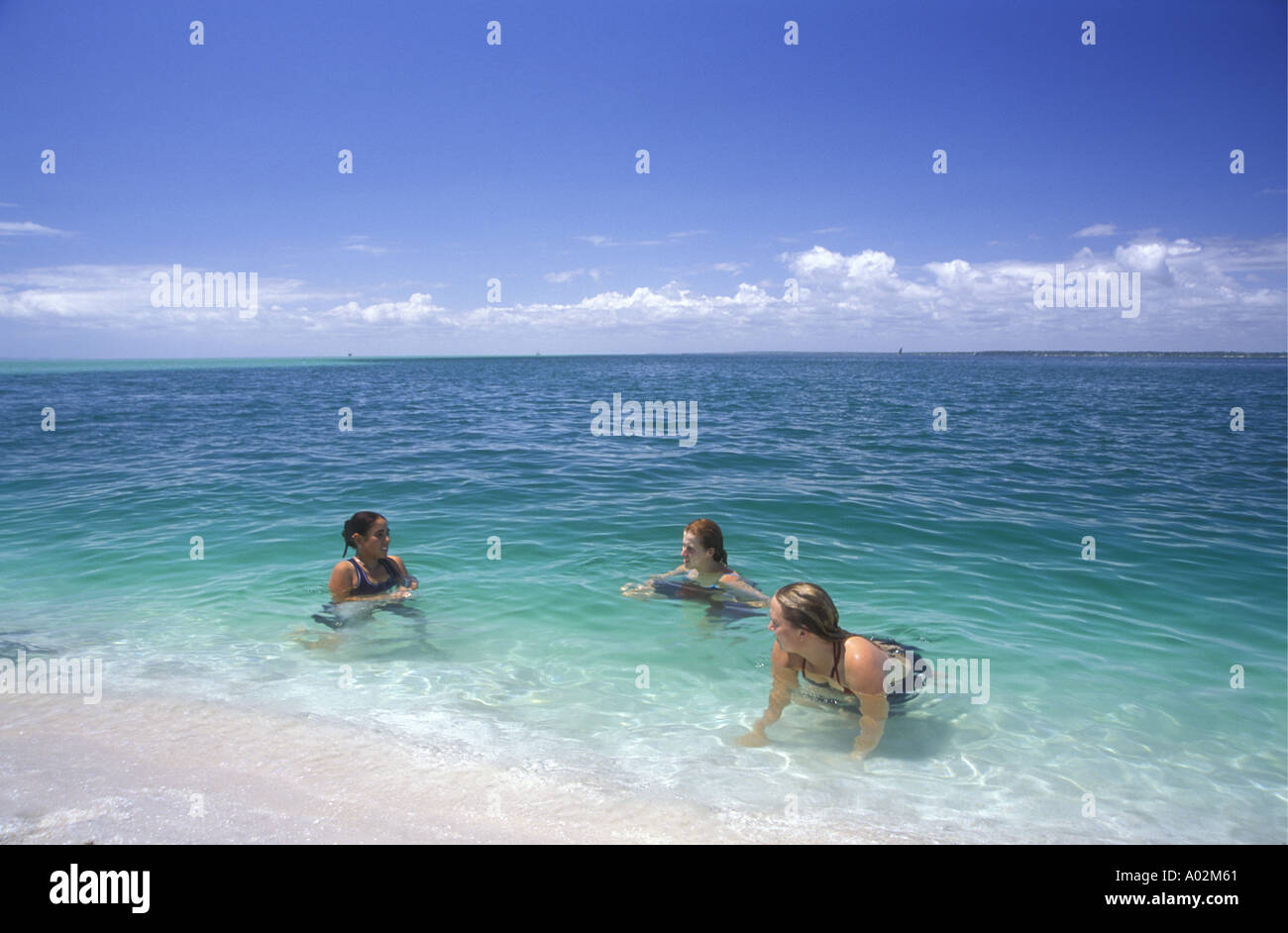 Los blancos jóvenes niñas disfrutando del agua pura en un arenal cercano isla Benguerra Mozambique África Foto de stock