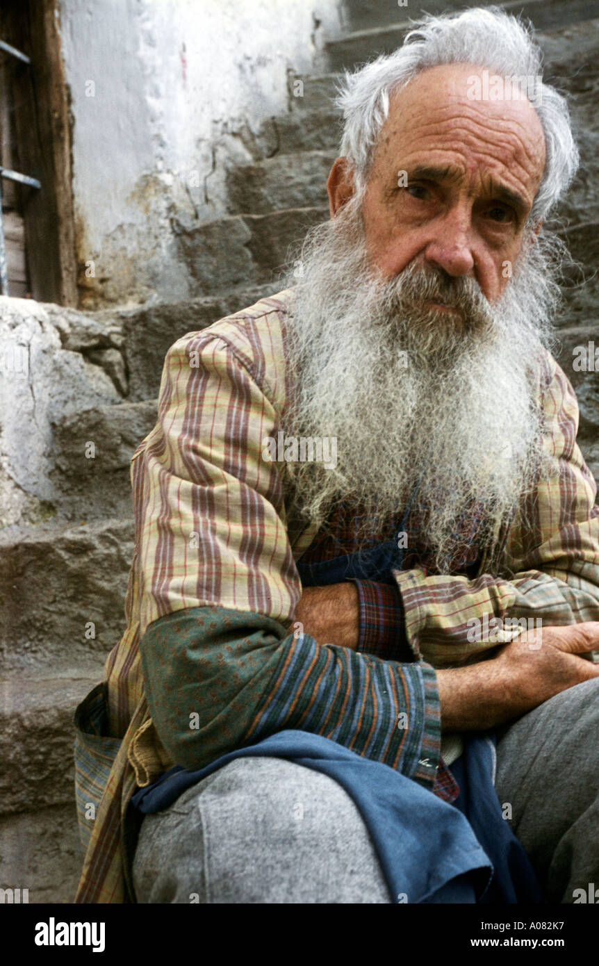 Anciano sentado en las escaleras mirando a la cámara Tirol ITA ITALIA Foto de stock