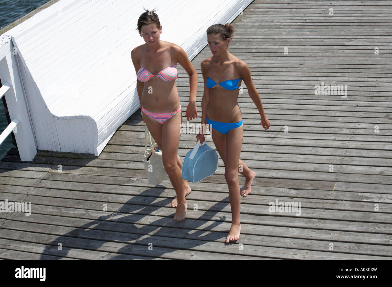 Dos niñas slim con bikiníes caminar sobre una pasarela Fotografía de stock  - Alamy