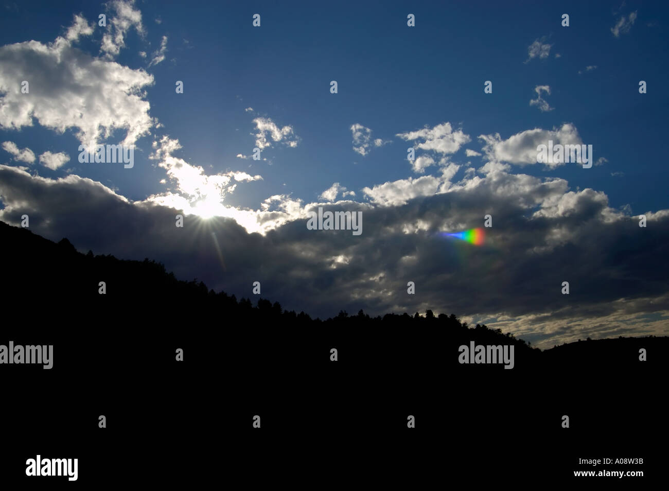 Un tiro en el atardecer con el sol oculto y provocando destellos en la lente Foto de stock
